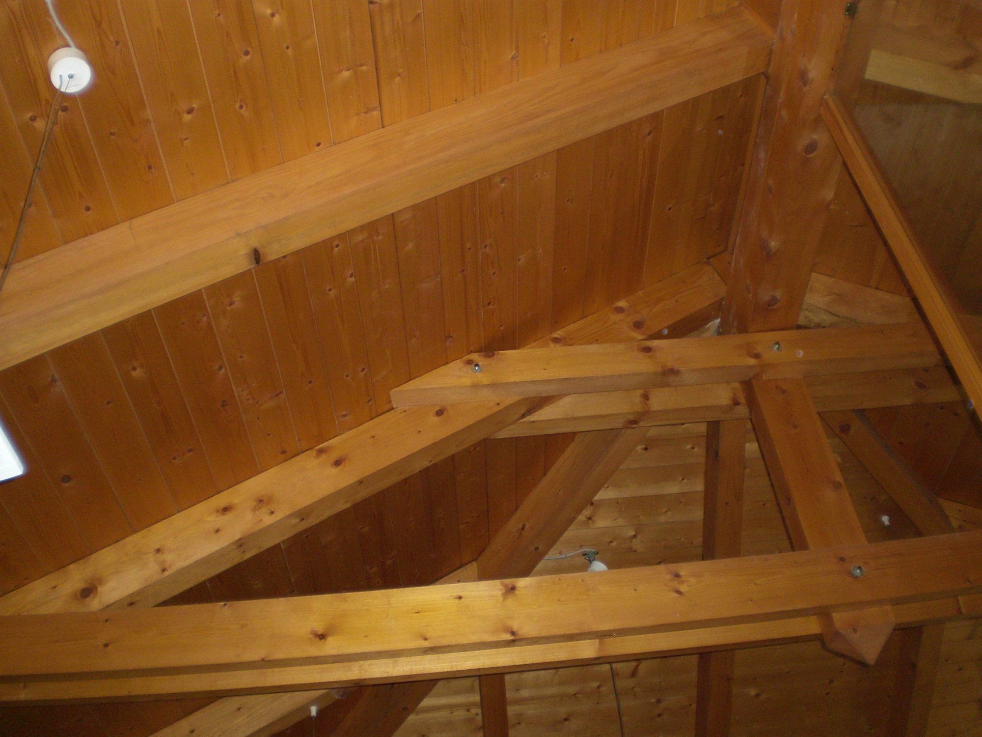 Interno di un tetto in legno con capriate e perline