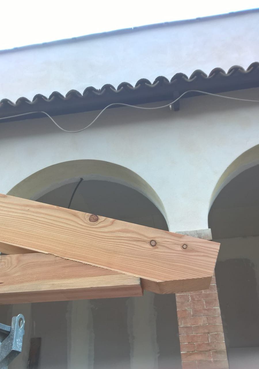 Trave in legno appoggiata su un porticato ad archi